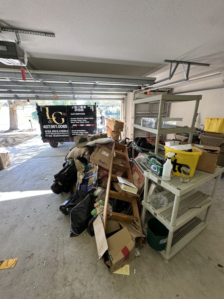 L&G Junk Removal trailer parked in front of a garage full of unwanted items during a garage cleanout service in Orlando, FL.