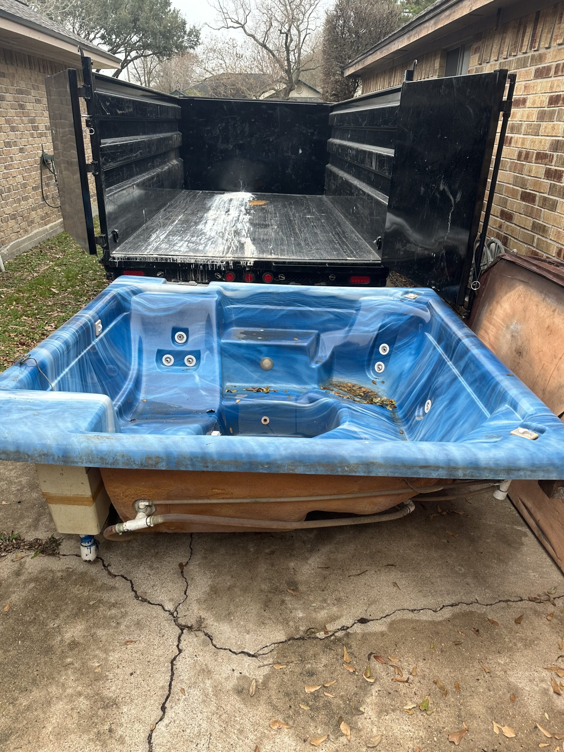 L&G Junk Removal trailer hauling a removed hot tub after a hot tub removal service in Orlando, FL.